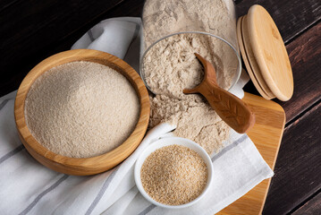 Raw organic amaranth grain and amaranth flour. Amaranth seeds in a wooden bowl on a table.