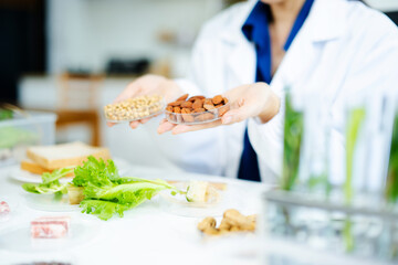 Nutrition expert in lab coat presenting soybeans and almonds in petri dishes. Healthy food, protein, diet, and food science concept. Clinical setting