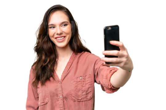 Young caucasian woman over isolated background making a selfie with mobile phone