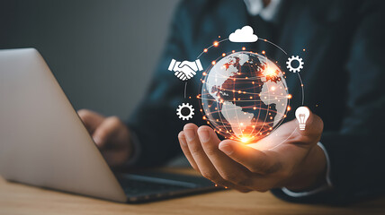 Businessman holding glowing digital globe with business icons and laptop global technology