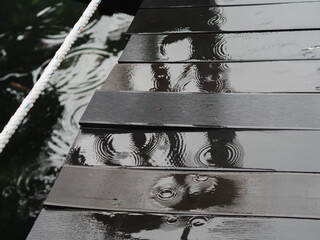 Rain soaked pier with ripple patterns and reflections