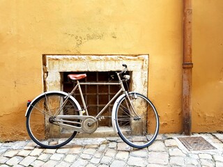 Old bicycle leaning against a yellow wall in the old town of Lisbon, Portugal