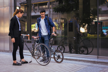 Obraz premium Commuting to work with bicycle. Businessman businesswoman cycling to office in downtown district. Modern diverse people use eco transportation on city street. Environmental pollution, climate change.