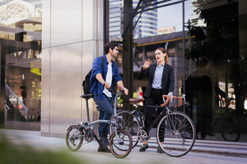 Commuting to work with bicycle. Businessman businesswoman cycling to office in downtown district. Modern diverse people use eco transportation on city street. Environmental pollution, climate change.
