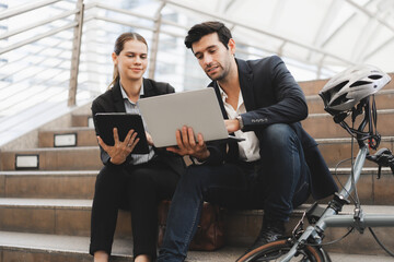 Commuting to work with bicycle. Businessman businesswoman cycling to office in downtown district....