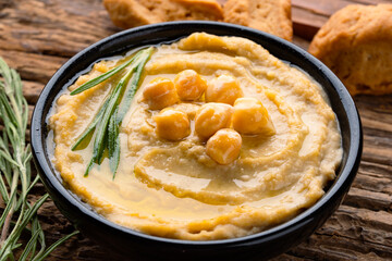 A traditional dish or appetizer hummus or baba ghanoush on wooden background	

