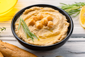  A traditional dish or appetizer hummus or baba ghanoush on white wooden background