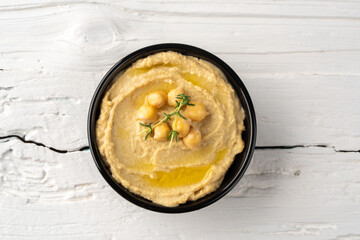  A traditional dish or appetizer hummus or baba ghanoush on white wooden background