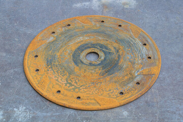 Rusty circular metal disc with holes corrosion texture industrial background old machinery spare part
