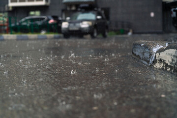 rain in the city, the flow of water along the city street during a downpour, bubbles, drops and...