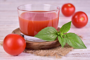 Tomato juice in a glass with a basil leaf. Close-up.
