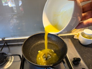 Pouring Beaten Eggs into Frying Pan with Hot Oil