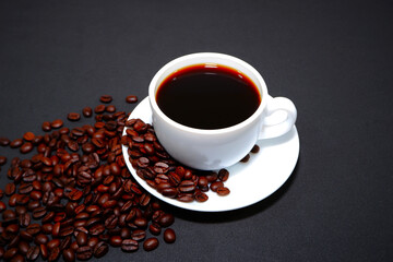 cup of coffee with beans closeup shot on black background 