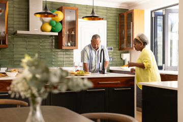 Senior couple enjoying cooking together in modern kitchen, sharing joyful moment