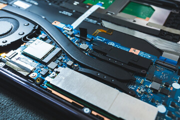 Close-up image of an all-in-one computer interior showing the motherboard, heat pipe cooling system, RAM slot, processor, and electronic components. Inside View of All-in-One Computer Motherboard