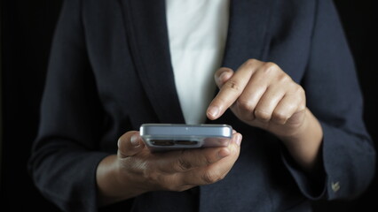 Close up of businesswoman using smartphone for communication, technology, online marketing, mobile banking, digital work, social media, and modern business innovation in daily life.
