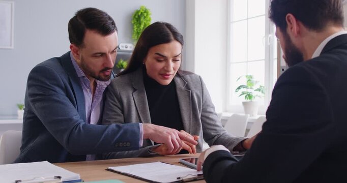 Agent consulting couple, supervisor explains to analyse financial report, pay attention on contract, propose ideas, professional insurance agent discussing terms conditions with family clients 