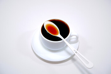 Black coffee with cup and saucer closeup shot on white background 