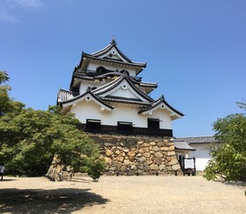 Traditional Japanese castle tower under clear blue sky