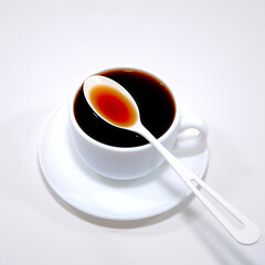 Black coffee cup and saucer with white background close-up view 