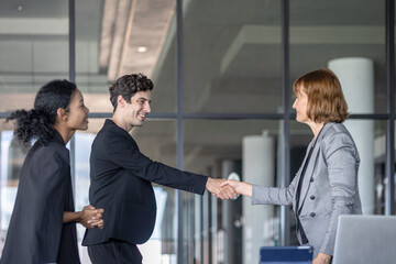 Business team from diverse cultures, genders, and generations celebrate the success hitting targets. Group of office workers express their appreciation to each other at the balcony. Cross generations