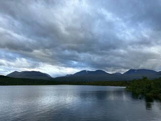 Serene Torneträsk lake under a dramatic sky with the mountains of Abisko National Park, Kiruna, Norrbotten, Sweden, August 2024