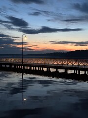 Obraz premium Pier with a lampost at dusk reflected in the serene Necko lake, Augustów, Podlasie, Poland, May 2024