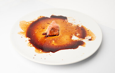 Spilled Soy Sause Leftovers with a Piece of Fish Isolated, Teriyaki Drops on White Plate, Oyster Sauce