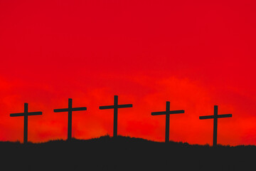 Silhouette of wooden crosses on mountain with red sky and dark tone, Symbol of God loved to people on hilly, The Christian cross seen as a representation of the instrument of the crucifixion of Jesus.