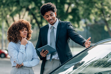 agent or salesman showing a car to a customer, buying a car