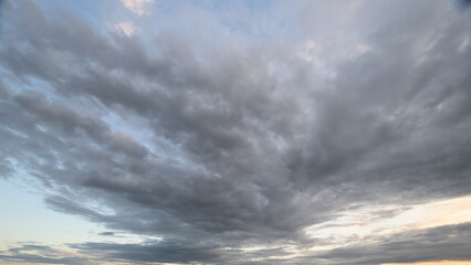 Fototapeta premium Stunning and Dynamic Cloud Patterns Appearing at Sunset in a Beautiful Landscape Scene