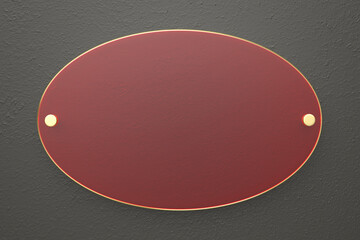 Oval red glass nameplate with golden edge on dark grey wall, front view