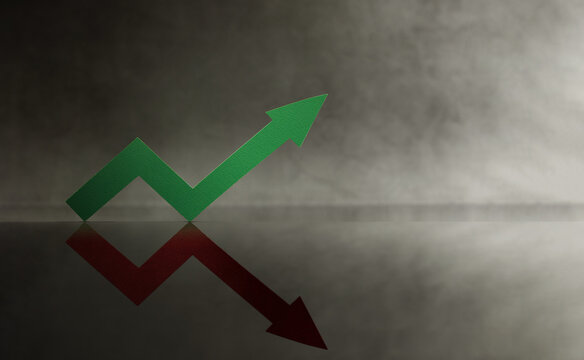 Green arrow points upward while red shadow downward. Financial uncertainty, risk, and the dual nature of economic movement