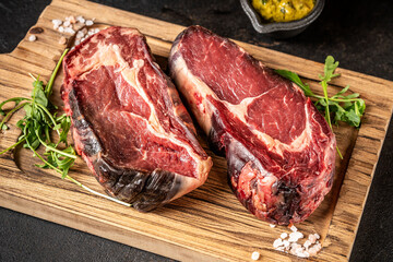 Fresh dry-aged ribeye steaks on cutting board