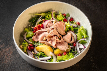 Fresh salad with duck breast, pomegranate, and greens