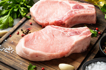 Raw pork meat on cutting board with spices. Close up image.