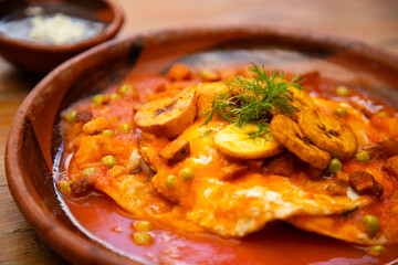 Huevos Motuleños are a Mexican breakfast, typical of the city of Motul, Yucatán. The dish is based on a fried tortilla with refried black beans and a fried egg on top.