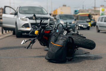 The motorcycle lies on the sidewalk after a ride. Serious accident. Accident, close-up. Lost control and fell. Driving hazards. Collisions with another vehicle.
