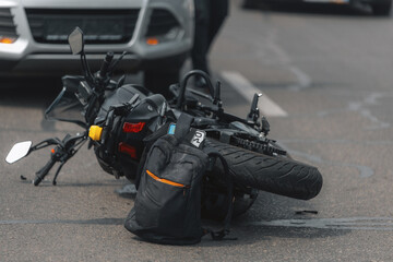 The motorcycle lies on the sidewalk after a ride. Serious accident. Accident, close-up. Lost control and fell. Driving hazards. Collisions with another vehicle.