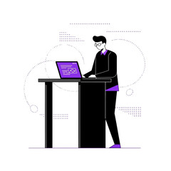 Man standing at a desk working on a laptop