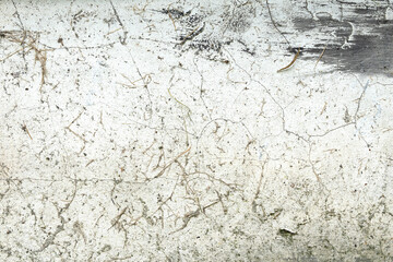 Close up of very dirty old white plaster wall with cracks and concrete drops
