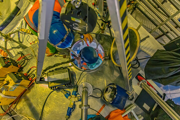 Top view male climbs up the stairs into the tank stainless chemical area confined