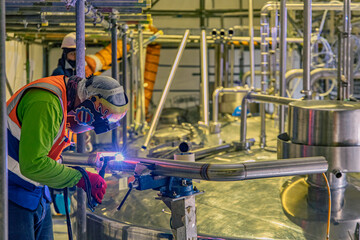 Welding arc argon worker male repaired pipeline stainless chemicals is welding sparks industrial