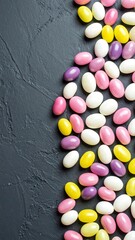 Obraz premium Colorful oval candies on dark surface