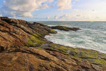 Rocky Coastline Meeting the Ocean Under a Cloudy Sky