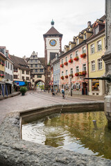 Fototapeta premium Sunny Morning at Schwabentor, Freiburg: Bikes, Fountain and Old Town Charm