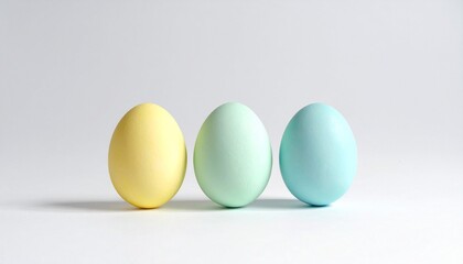 Three pastel plastic eggs—blue, green, yellow—upright on white background