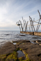Pier with a wooden structure for fishing, a typical feature of the coast of Savudrija, in Istria, Croatia. It represents the local maritime tradition and the work of fishermen.