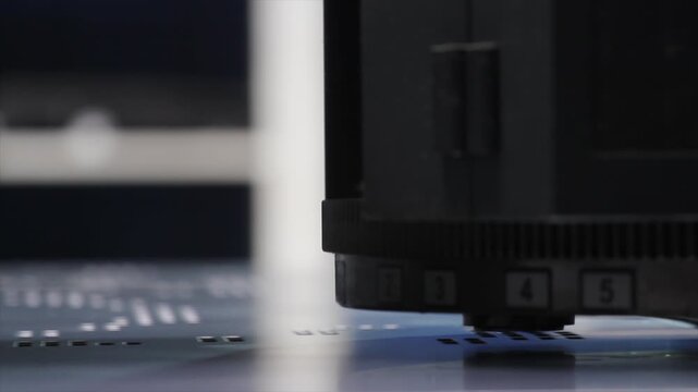 Extreme close-up of a turret punch press using custom tooling to cut precise patterns into sheet metal.
