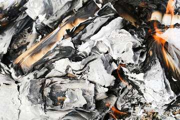 Burning documents with flames. Paper turning into ashes. Destroyed files smoldering in fire. Concept of evidence elimination. Risk of illegal activity. Heat destruction process. Danger of fire closeup